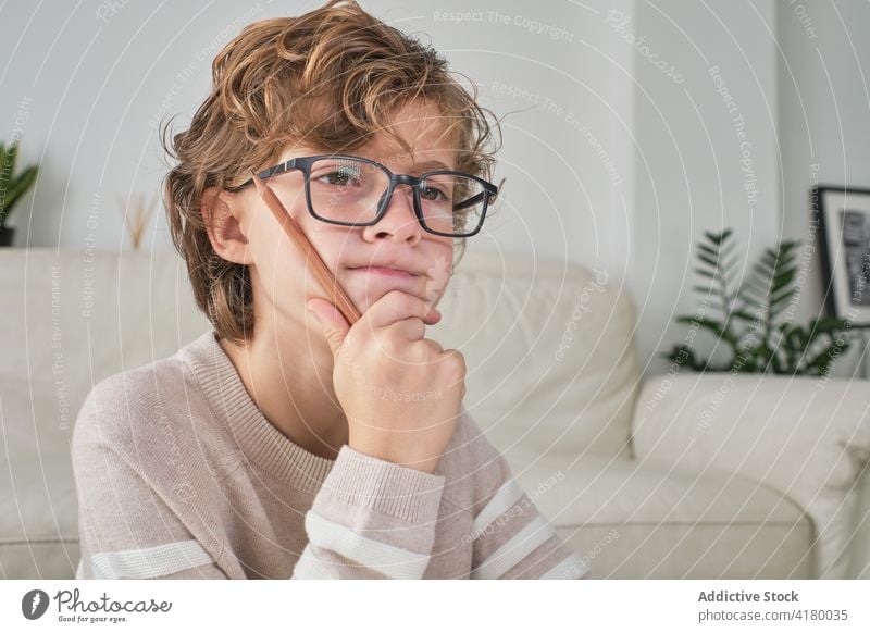 Expressive Boy Portrait portrait young boy thinking expressive expression at home cozy looking at front glasses thoughts thoughtful background front view pencil