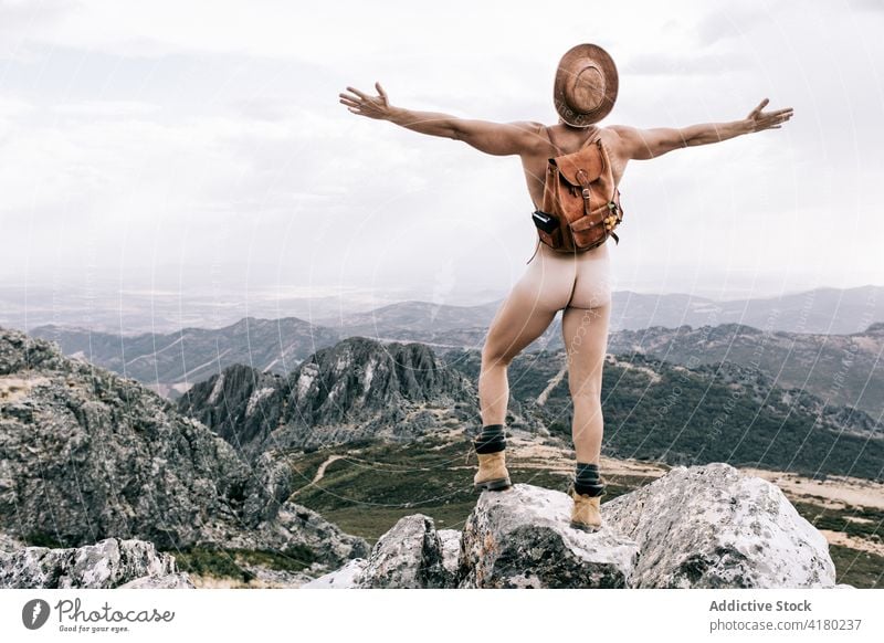 Naked traveling man enjoying freedom in mountains naked carefree outstretch nude explorer backpack male journey tourism idyllic serene peaceful body rock nature