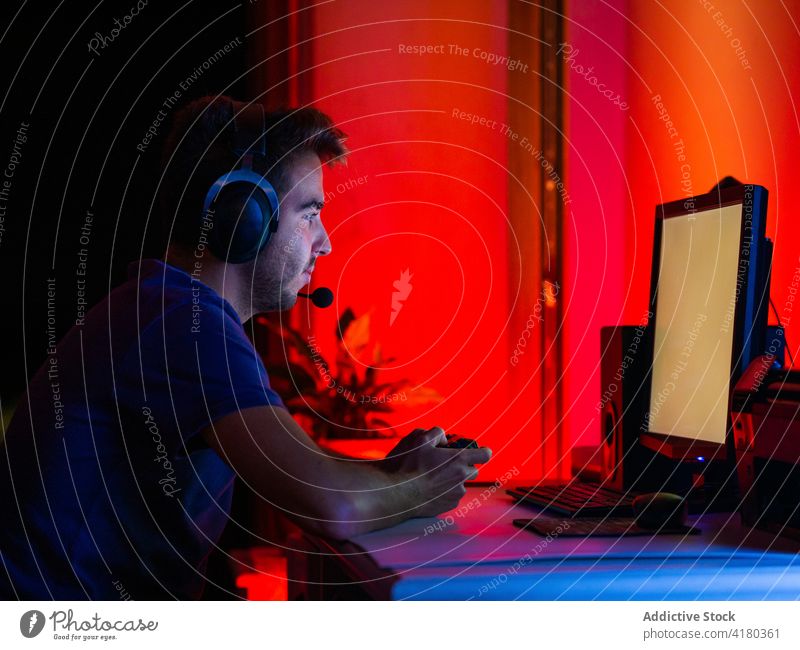 Man in headphones using modern computer in dark room man monitor browsing darkness gadget calm work blank screen empty screen watch pc social media contemporary