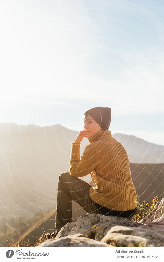 Traveler sitting on rock in mountains traveler viewpoint observe highland hiker enjoy admire explore amazing scenery valley trekking adventure sunny wonderful