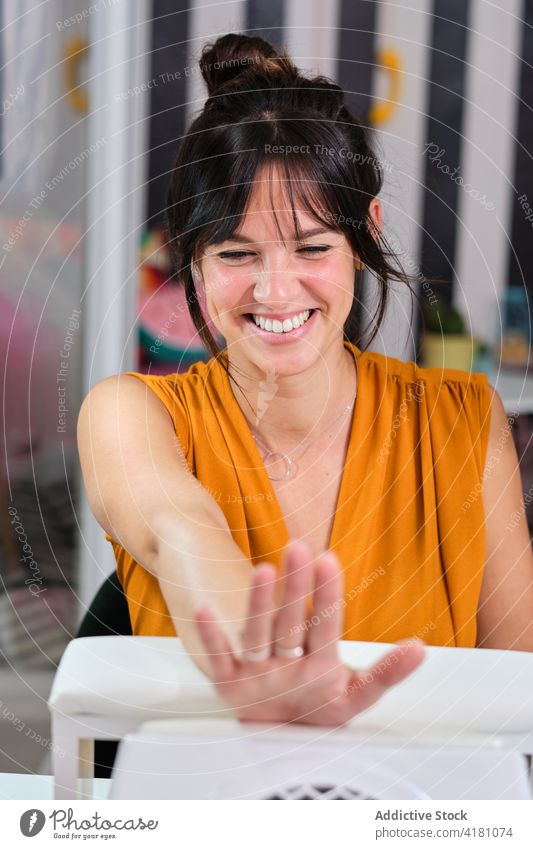 Joyful woman enjoying manicure session in salon client happy satisfied smile beauty professional service procedure treat cheerful female glad lifestyle