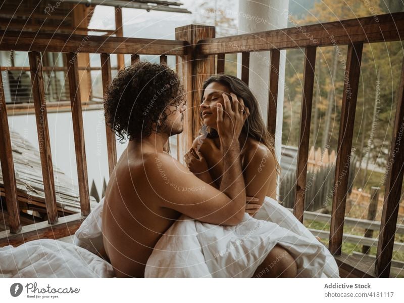 Naked couple caressing on blanket on terrace cuddle autumn romantic gentle fondness relationship naked soulmate season bonding hug porch undress affection