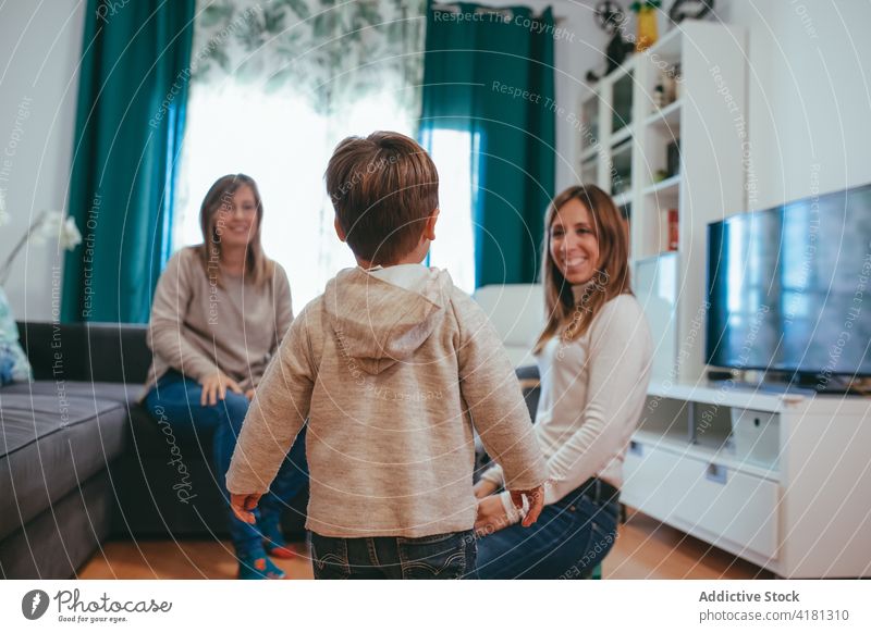 Happy homosexual family playing with kids in living room couple lesbian son smile happy carefree having fun parent mother childcare alternative lgbtq joy