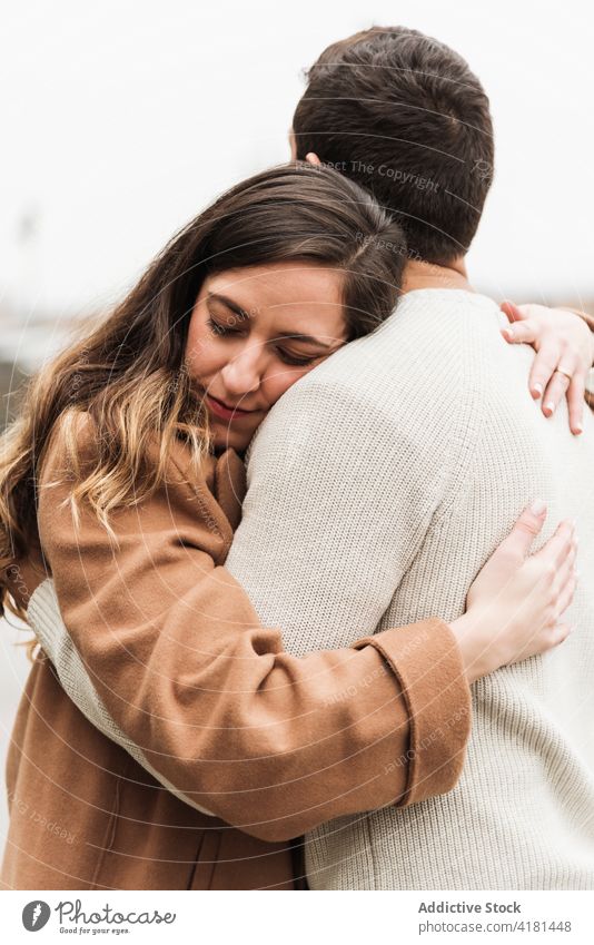 Young couple embracing on street hug embrace romantic autumn relationship soulmate affection happy sidewalk love season warm clothes together young girlfriend