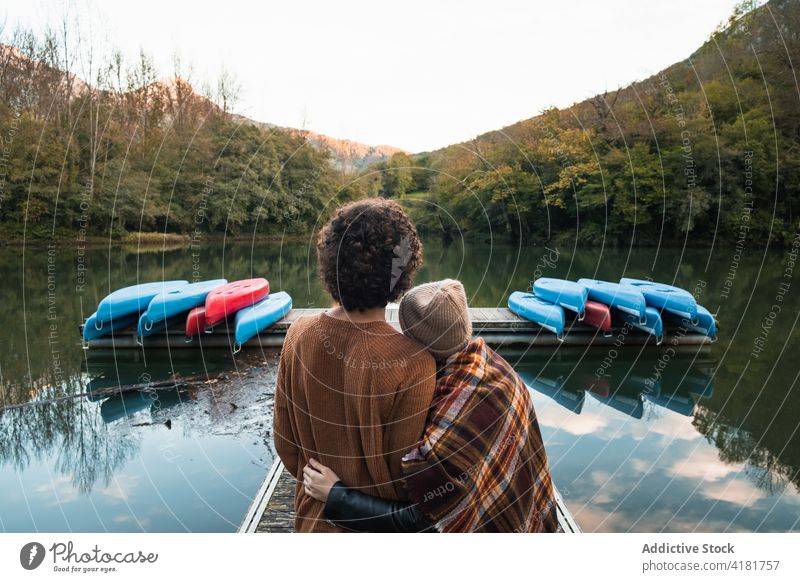 Romantic couple standing on lake pier surrounded by verdant forest reservoir valdemurio relationship love tender lakeside nature romantic quay together young