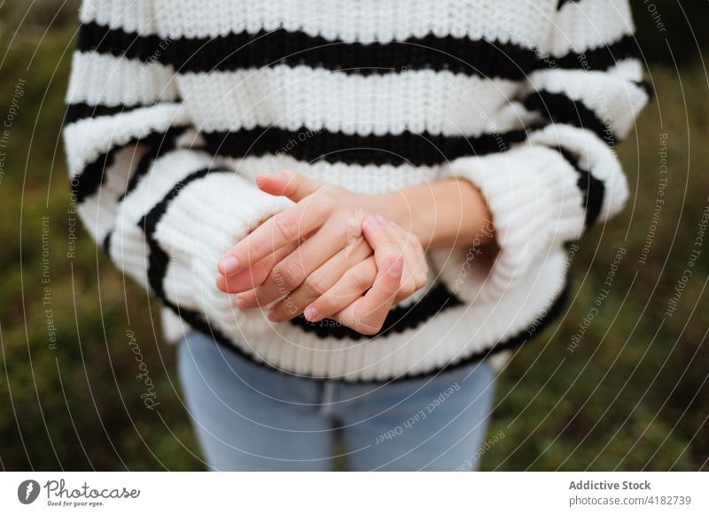 Faceless traveler with clasped hands on mount hands clasped friendship gentle tender gesture trip vacation mountain woman sweater knitted nature show ornament