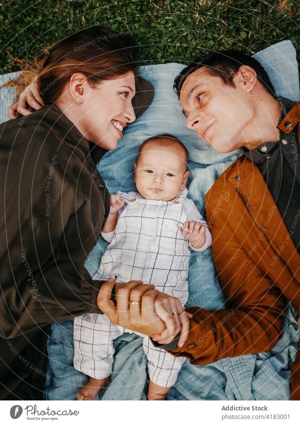 Happy family with baby resting in park together love happy parent relationship bonding care infant child mother father kid parenthood childhood mom enjoy