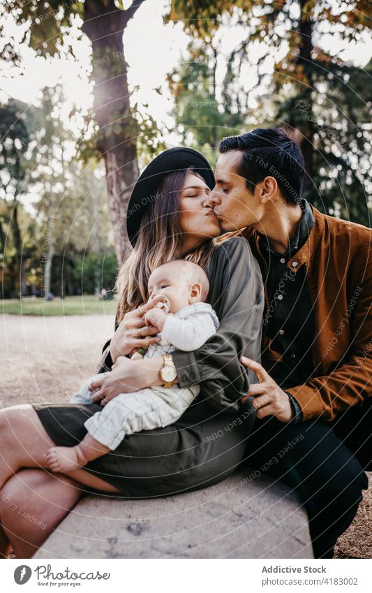 Happy family with baby resting in park together love happy parent relationship bonding care infant child mother father kid parenthood childhood mom enjoy