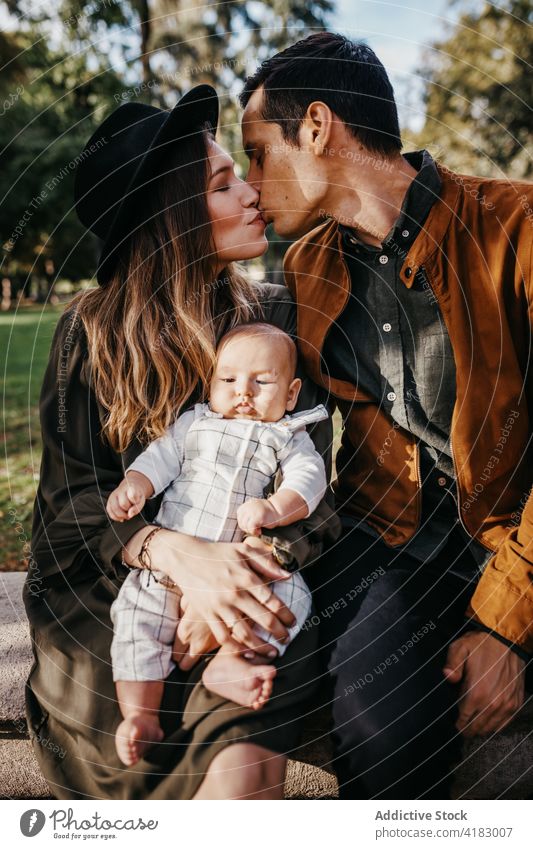 Happy family with baby resting in park together love happy parent relationship bonding care infant child mother father kid parenthood childhood mom enjoy