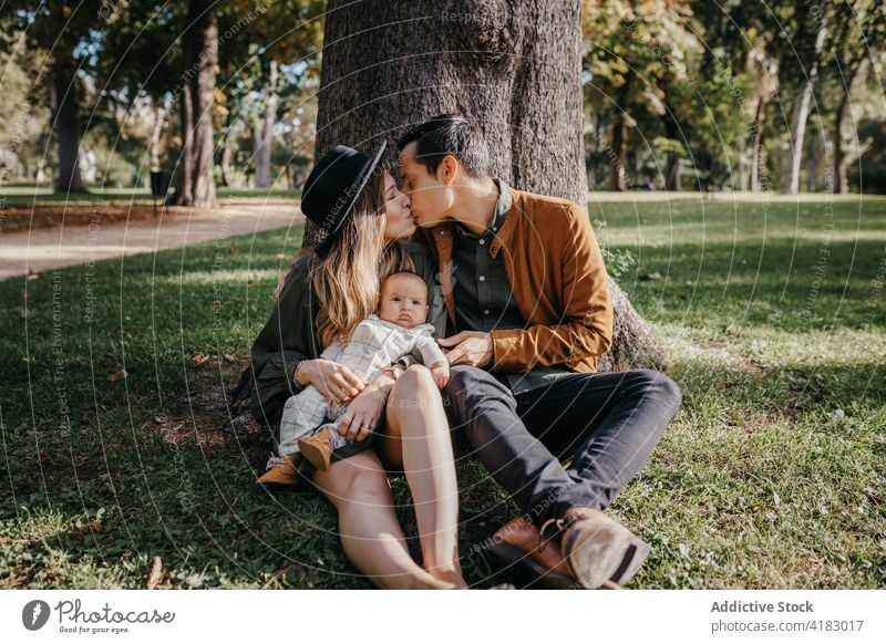 Happy family with baby resting in park together love happy parent relationship bonding care infant child mother father kid parenthood childhood mom enjoy