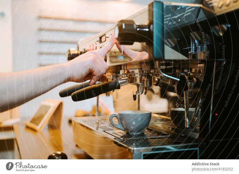 Crop barista preparing hot coffee in cafe coffeemaker prepare coffee shop machine cup drink man modern male professional beverage work staff service job