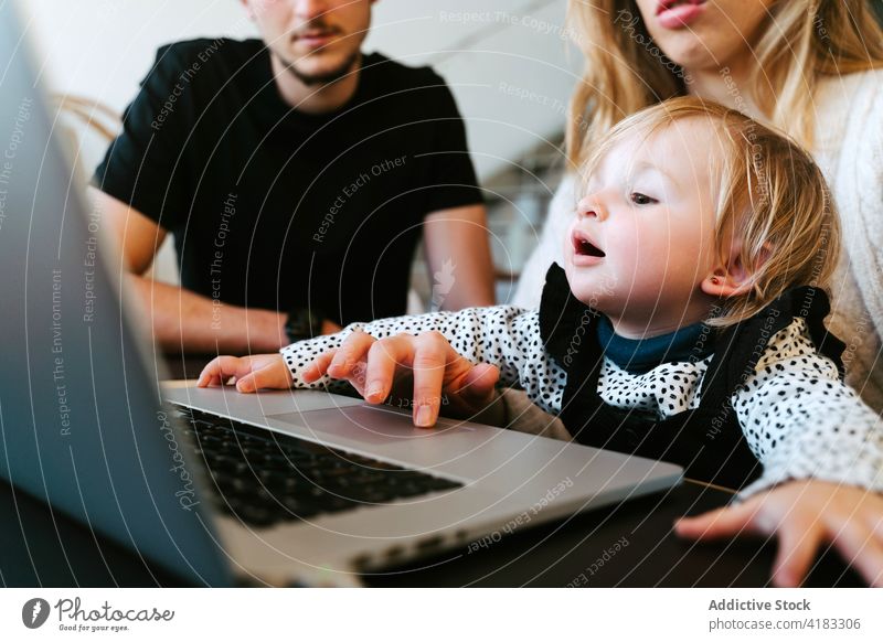 Family watching movie on laptop together at home family toddler weekend couple little child table bonding sit young device joy gadget happy affection cheerful