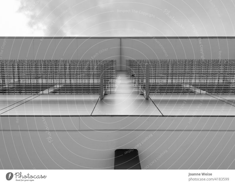 View up building wall to roof, metal window frames and sky. Building Wall (building) Metal Sky Black & white photo Exterior shot Shadow Gray Contrast Day