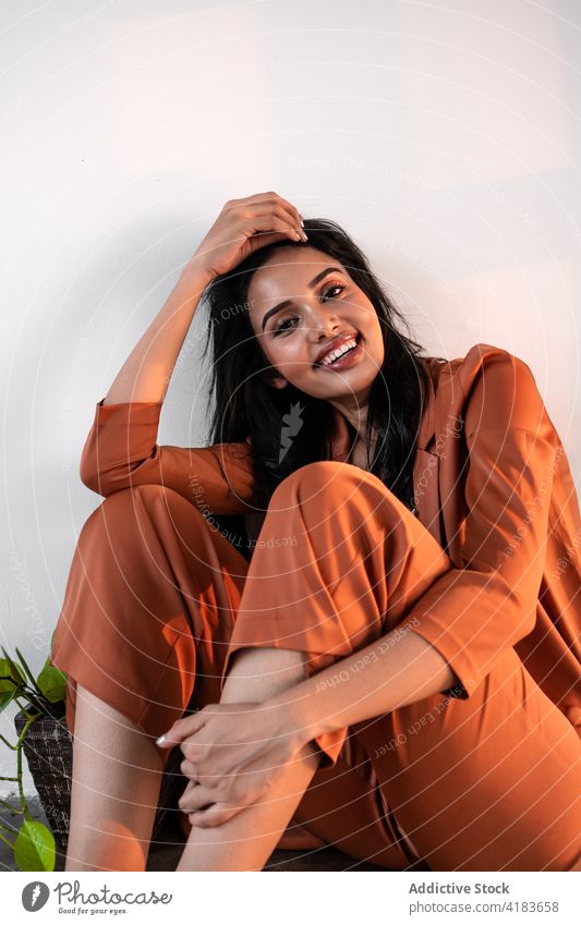 Relaxed stylish woman sitting on floor relax sensual style rest enjoy dreamy peaceful tranquil serene young ethnic female feminine calm barefoot beautiful