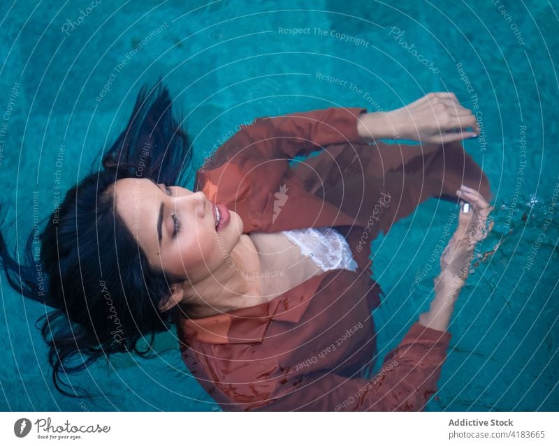 Sensual woman floating in lake water relax tranquil enjoy nature serene harmony young ethnic female tropical rest calm peaceful recreation sensual dreamy