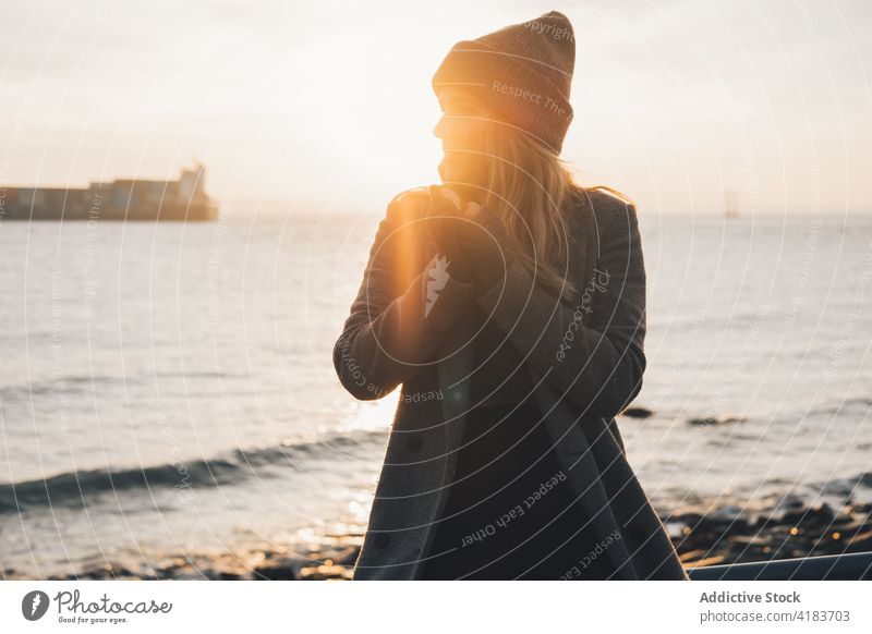 Happy woman enjoying sunset at seaside autumn admire happy smile shore young female evening lifestyle sundown relax rest ocean coast season travel nature