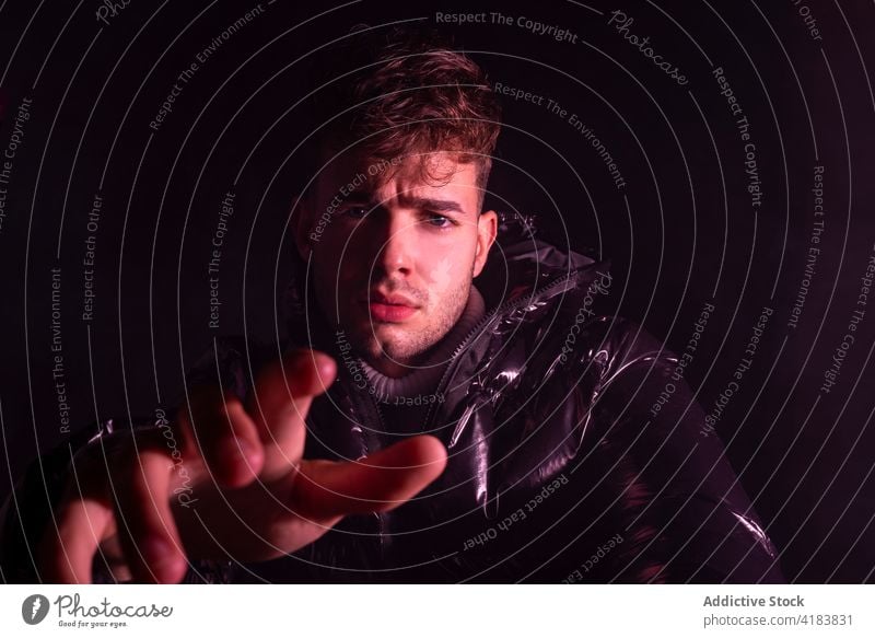 Pensive young man reaching to camera in black studio reach out thoughtful upset serious style appearance pensive wistful fashion handsome human face male