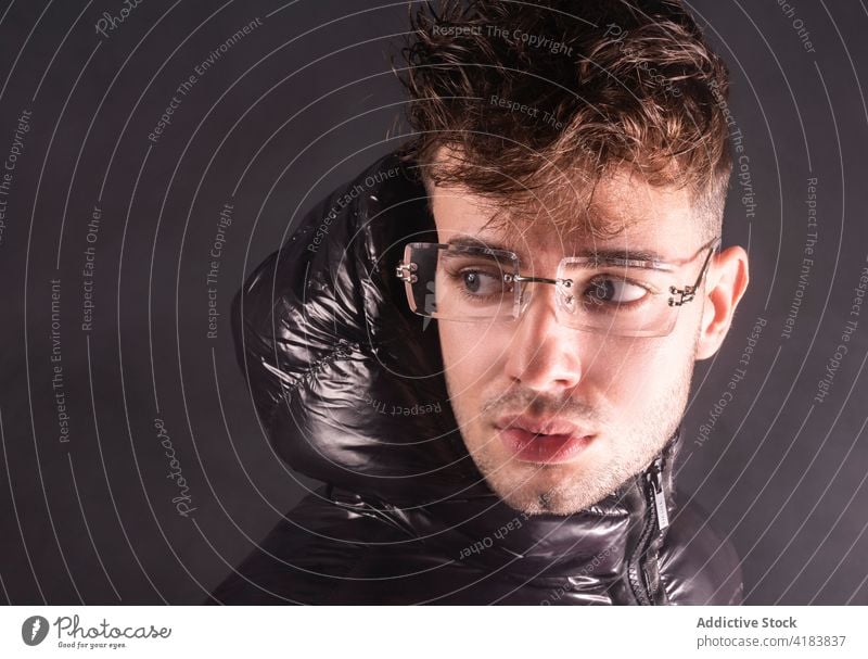 Pensive young man in black studio with smoke thoughtful serious style appearance pensive wistful fashion handsome human face male unshaven trendy outfit casual