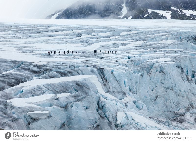 Group of hikers in mountains in winter rock terrain valley explorer group snow company norway spectacular highland landscape cold majestic rocky travel scenic