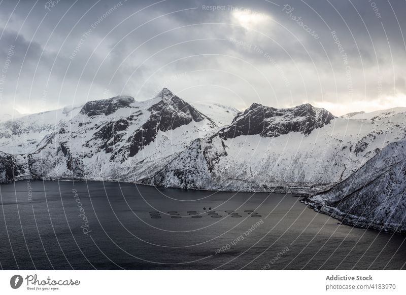 Fish farming in sea in mountainous terrain in winter fish pisciculture cold water cage circle norway snow round shape fishing landscape nature scenic