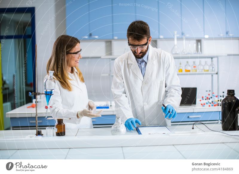 Researchers doing experiment with smoke on a table of a chemical laboratory analysis analyze chemist chemistry danger discovery experimental female formula