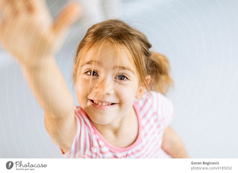 Cute little girl rising hand towards camera adorable beautiful caucasian cheerful child childhood closeup concept cute enjoy expression face female focus fun