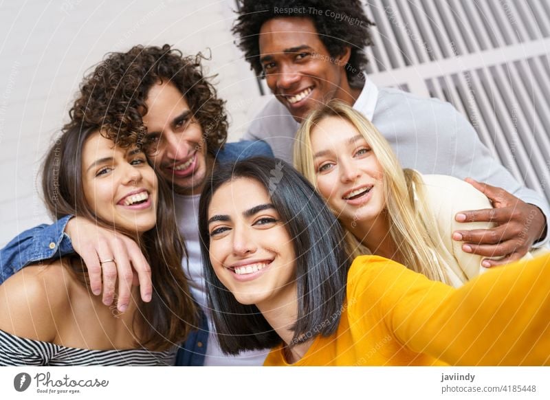 Multi-ethnic group of friends taking a selfie together while having fun outdoors. people smartphone multiracial multi-ethnic caucasian photographing students