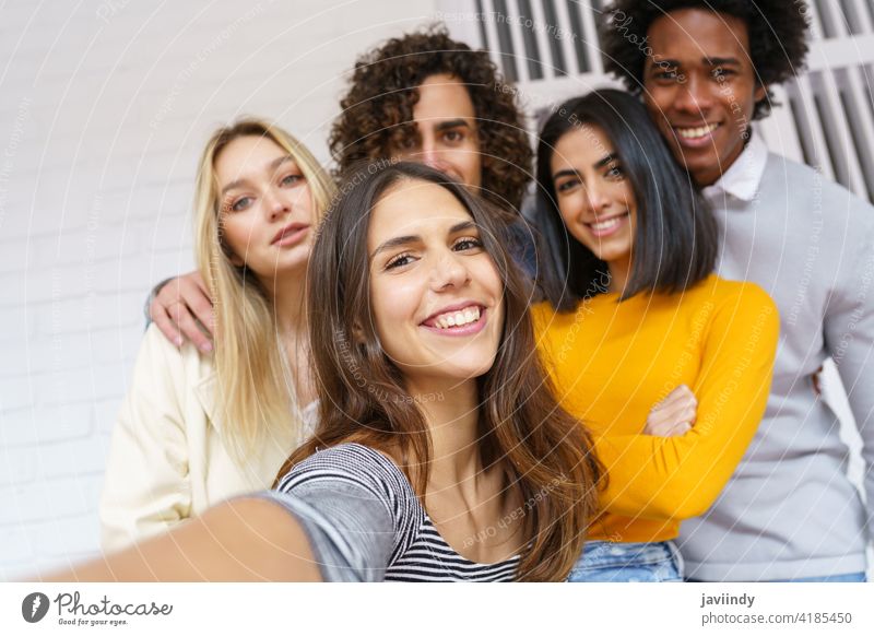 Multi-ethnic group of friends taking a selfie together while having fun outdoors. people smartphone multiracial multi-ethnic caucasian photographing students