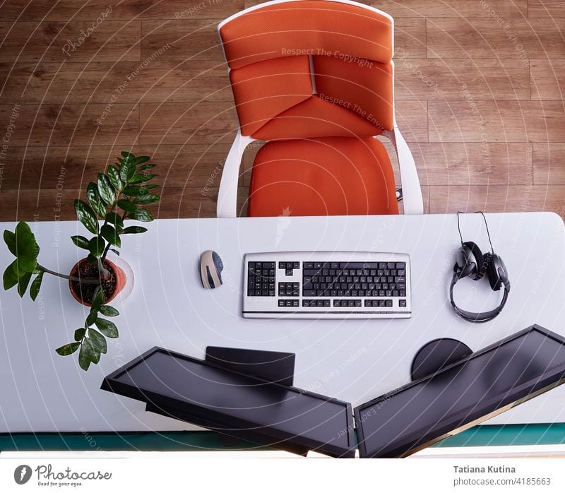 Home computer workstation top view. A wheeled chair, a large white desk, and two monitors workplace freelance table keyboard education home above lifestyle