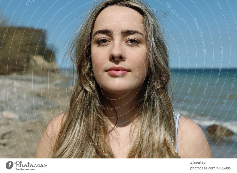 Beautiful blonde girl stands on the beach of the Baltic Sea and looks into the camera Girl Smiling joyfully Landscape Blonde Joy Exterior shot Face Young woman