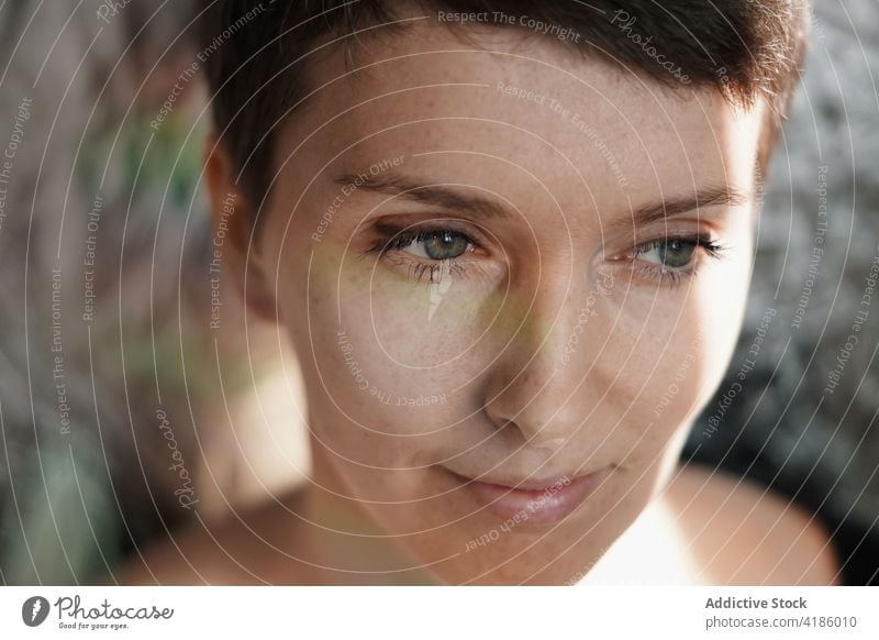 Graceful adult female with freckles looking away in sunlight woman feminine grace dreamy smile calm peaceful charismatic personality human face glad appearance