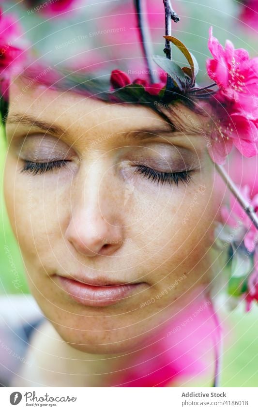 Tranquil adult lady resting in garden among blooming flowers woman recreation pensive calm nature idyllic harmony peaceful relax serene female short hair