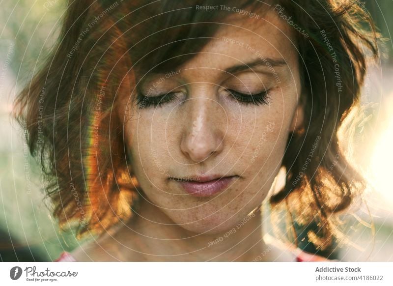 Dreamy woman looking down against sunset sky relax nature sunlight tranquil contemplate thoughtful grace calm golden hour peaceful female adult bright idyllic