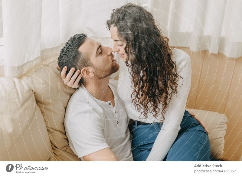 Gentle couple embracing on sofa at home bed embrace tender bedroom kiss forehead gentle relationship together weekend soft fondness affection bonding cuddle