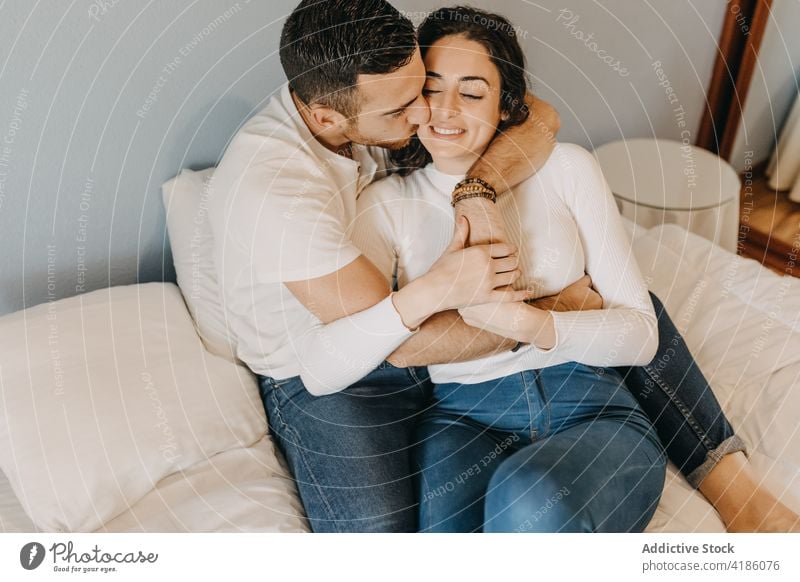 Gentle couple embracing on bed at home embrace tender bedroom kiss forehead gentle relationship together weekend soft fondness affection bonding cuddle romantic