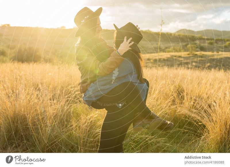 Content couple of women hugging in field lesbian having fun lift weekend together lgbt same sex relationship happy love girlfriend bonding romantic homosexual