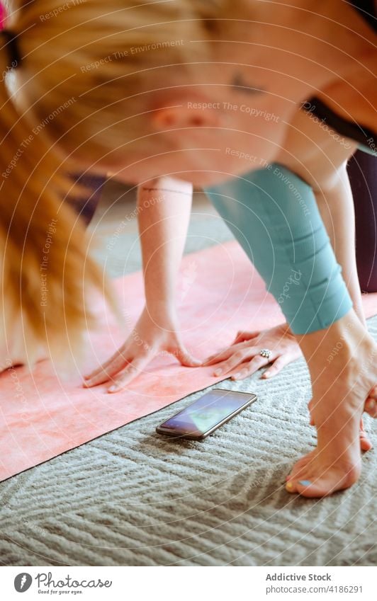 Flexible woman doing yoga in Crooked Monkey on Forearm pose with mobile phone asana practice flexible stretch female zen slim healthy wellness balance wellbeing