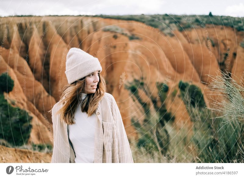 Smiling tourist standing in mountains smile nature tourism highland enjoy woman traveler ridge vacation journey sky cloudy trip idyllic content cheerful glad