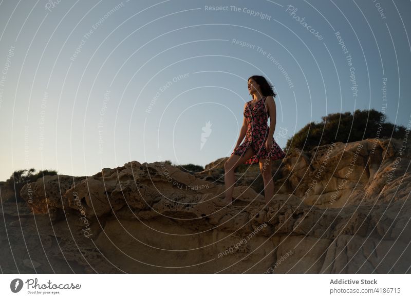 Woman dressed in a dress standing on a rock on a summer day female woman nature beautiful stone beauty lifestyle happy fashion outdoor beach young sunset hair