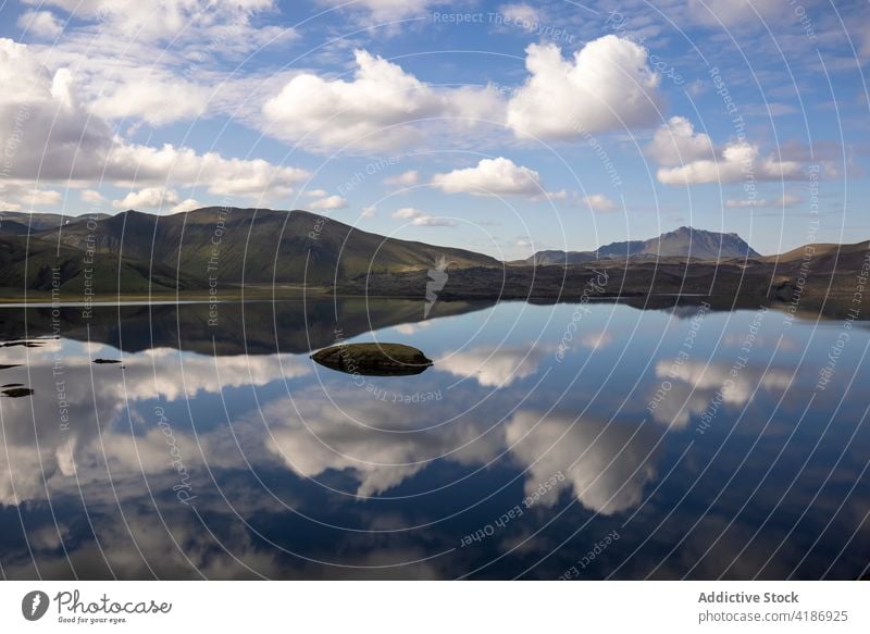 Calm lake surrounded by rocky hills hillside scenery reflect range wonderful highland nature rough formation iceland ridge pond environment tranquil amazing