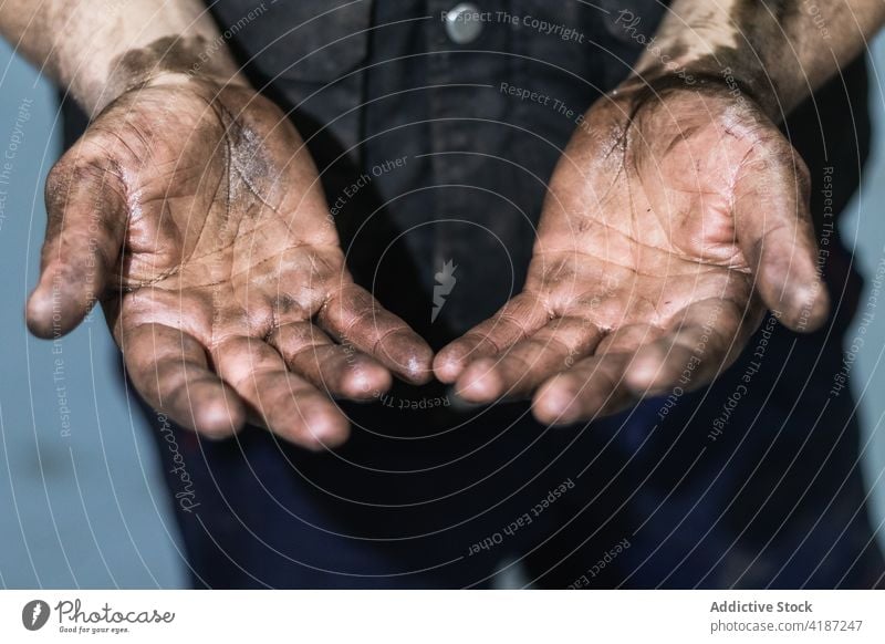 Mechanic showing dirty hands in car workshop mechanic service equipment men at work hard job repairman finger greasy person automobile engine industrial