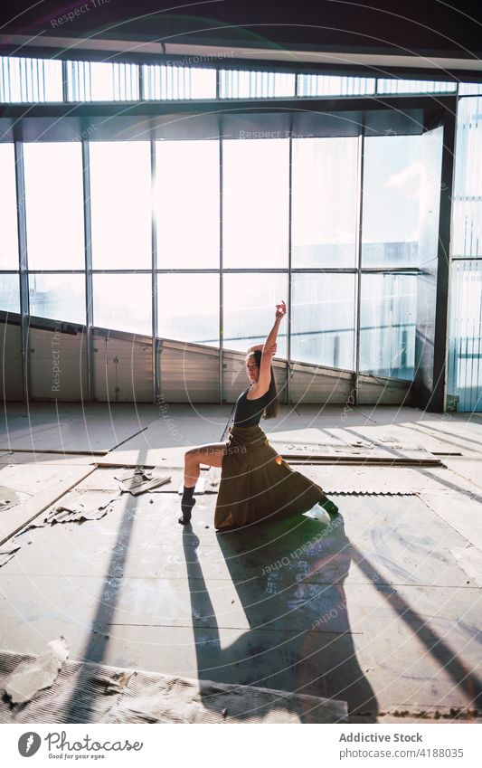 Dancer dancing in building during rehearsal artist dance choreography leg raised arm raised perform shadow theater woman prepare practice shade glass wall