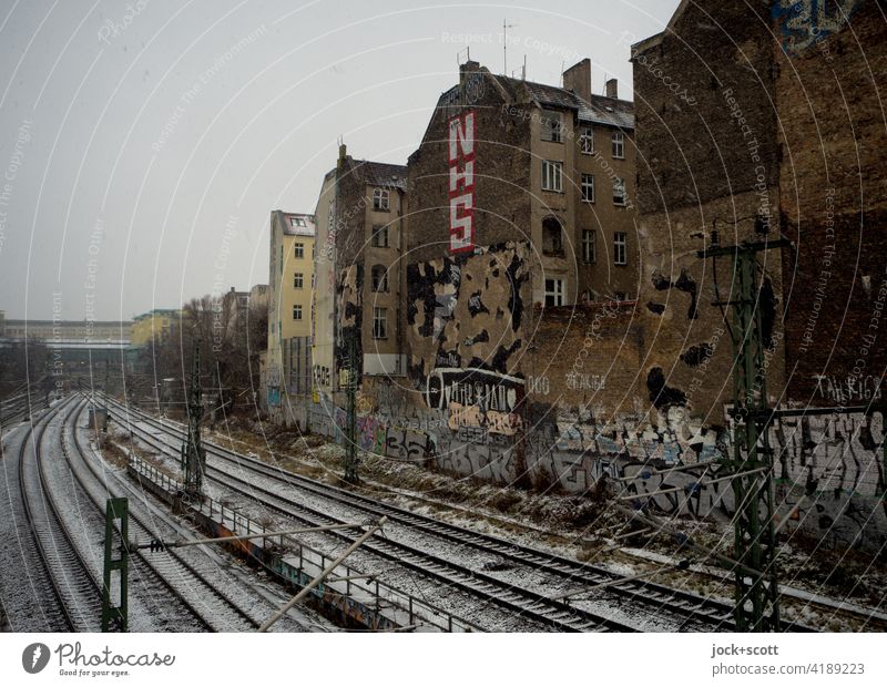 a winter day at the firewall Bad weather Facade Town house (City: Block of flats) Brick Graffiti Fire wall Architecture ring track Snowfall Train station