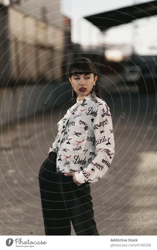 Thoughtful young ethnic female looking away while standing on street in suburb area woman pensive thoughtful style calm contemplate ponder tranquil dreamy