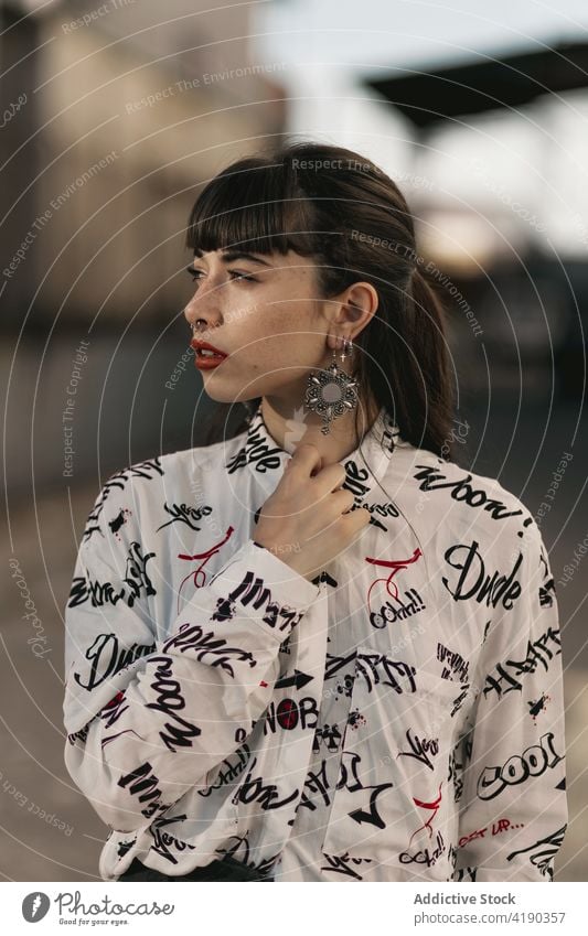 Thoughtful young ethnic female looking away while standing on street in suburb area woman pensive thoughtful style calm contemplate ponder tranquil dreamy