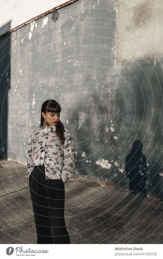 Thoughtful young ethnic female looking away while standing on street in suburb area woman pensive thoughtful style calm contemplate ponder tranquil dreamy