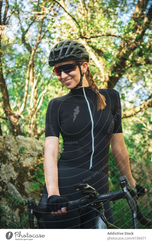 Cheerful woman with bicycle in nature sport activity cyclist rest break calm female active sportswoman helmet mountain alone healthy sporty hobby vitality lady