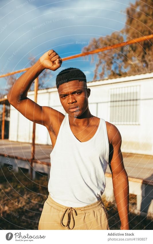 Black man with fist up in blindfold protester revolution disagree aggressive violent strong masculine displease macho dissatisfied countryside hide negate