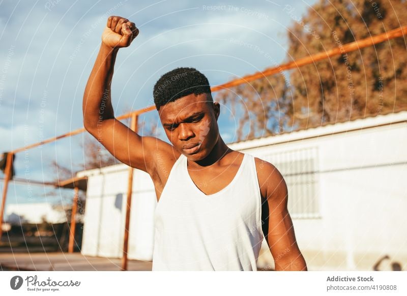 Black man with fist up in blindfold protester revolution disagree aggressive violent strong masculine displease macho dissatisfied countryside hide negate