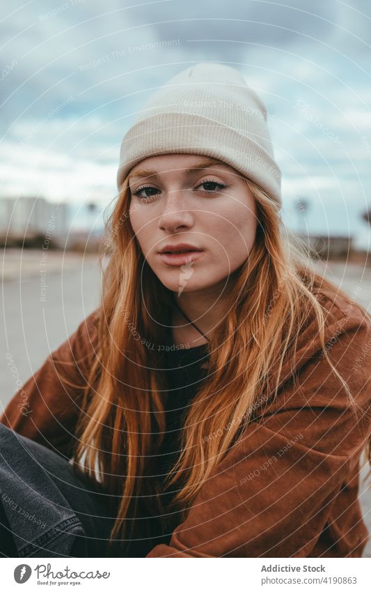 Stylish calm lady looking at camera on street woman confident style rest appearance personality tranquil street style city fashion young long hair ginger hair